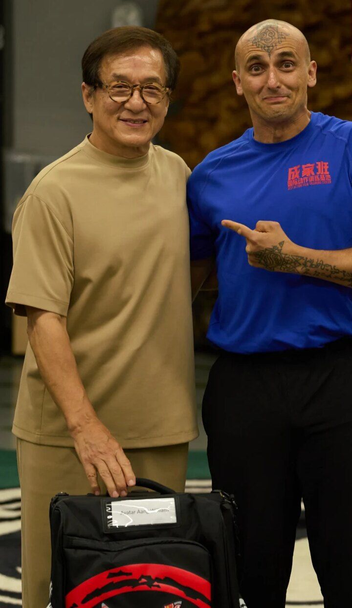 Aang Willians ao lado de Jackie Chan, apontando para ele, no JCST Action Film Camp 2025, em Pequim. 2025, do Instagram dele.