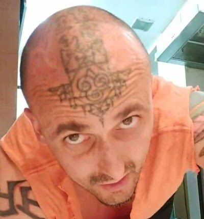 Aang Willians de camiseta laranja, em posição de flexão, olha para a câmera. 10 de janeiro de 2025, do canal dele no YouTube.