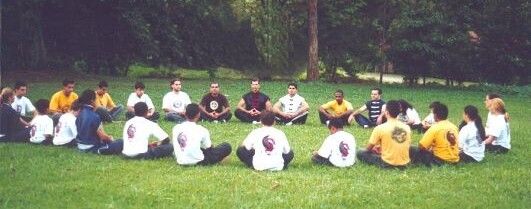 Gilmar Dantas e alunos meditam em círculo, ao ar livre.